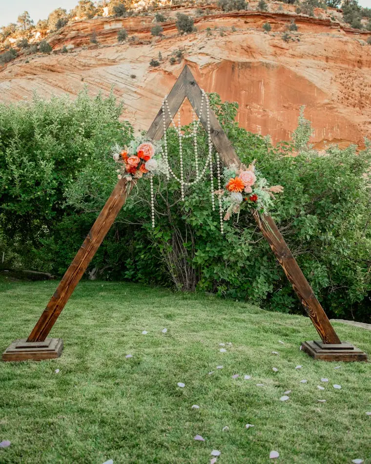 A triangular wedding arch dressed in white blooms