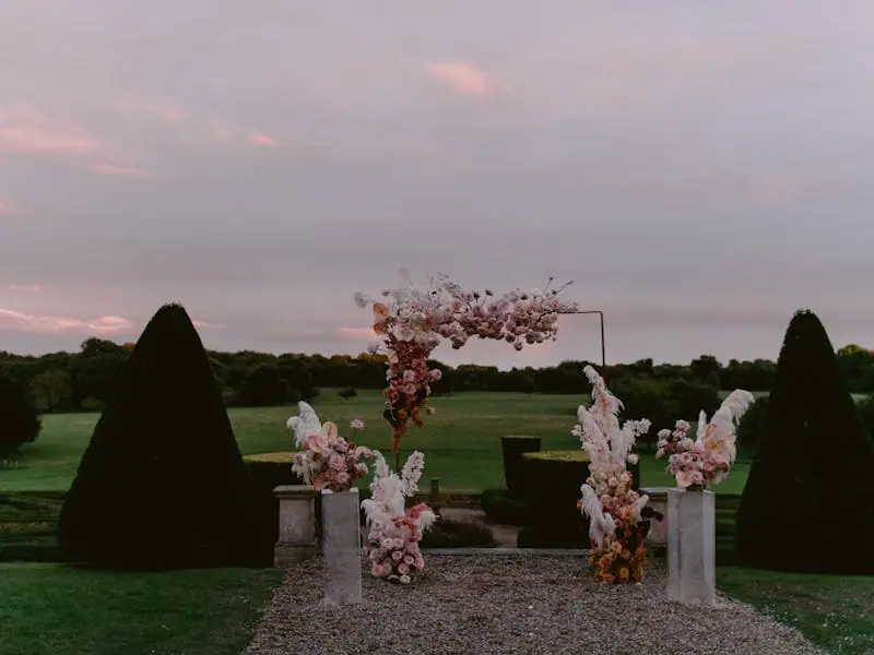 A petal-lined aisle leading to a feathered arch