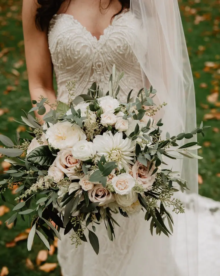 A bride holding a full bouquet of flowers