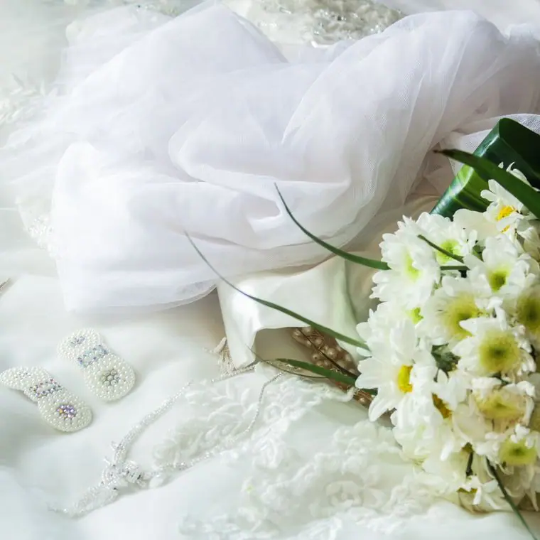 A bouquet resting beside a soft white veil